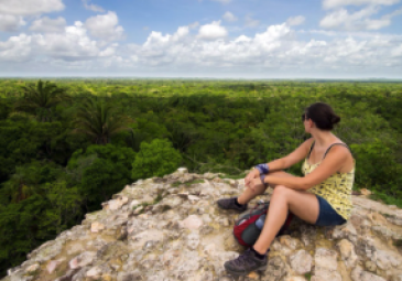 Speaker sitting on top of ruin, looking over the jungle.